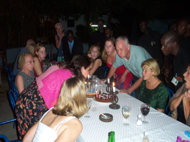 Geri, Morris and Others Attempt to Assist in the Blowing Out of the Cake